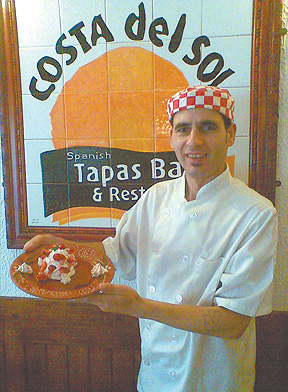 Restaurant owner, Joe Inacio holding the ‘Meringue al Gran Torres’ decorated with fresh strawberries.