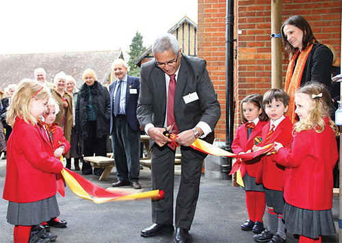 Lord Dholakia ceremoniously cuts the ribbon assisted by young pupils from Oakhyrst Grange School.